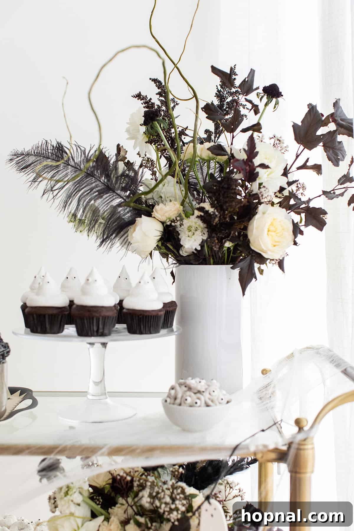 A meticulously arranged ghost Halloween treat bar with cupcakes and candies.