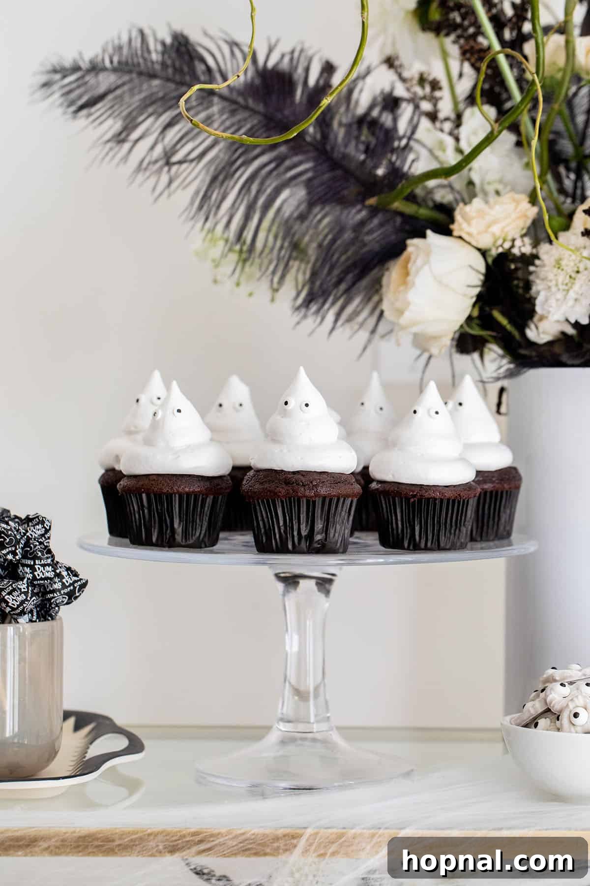 Ghost cupcakes decorated with playful edible eyes on a white frosting peak.