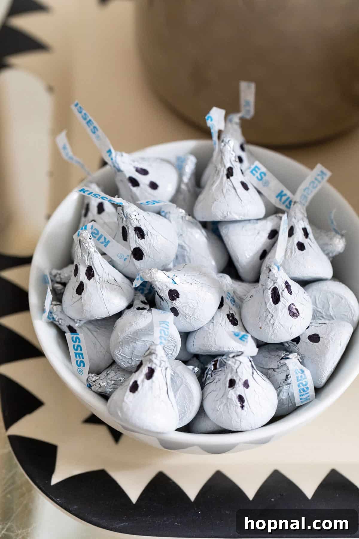 Hershey Kisses wrapped in white, decorated with ghost faces.