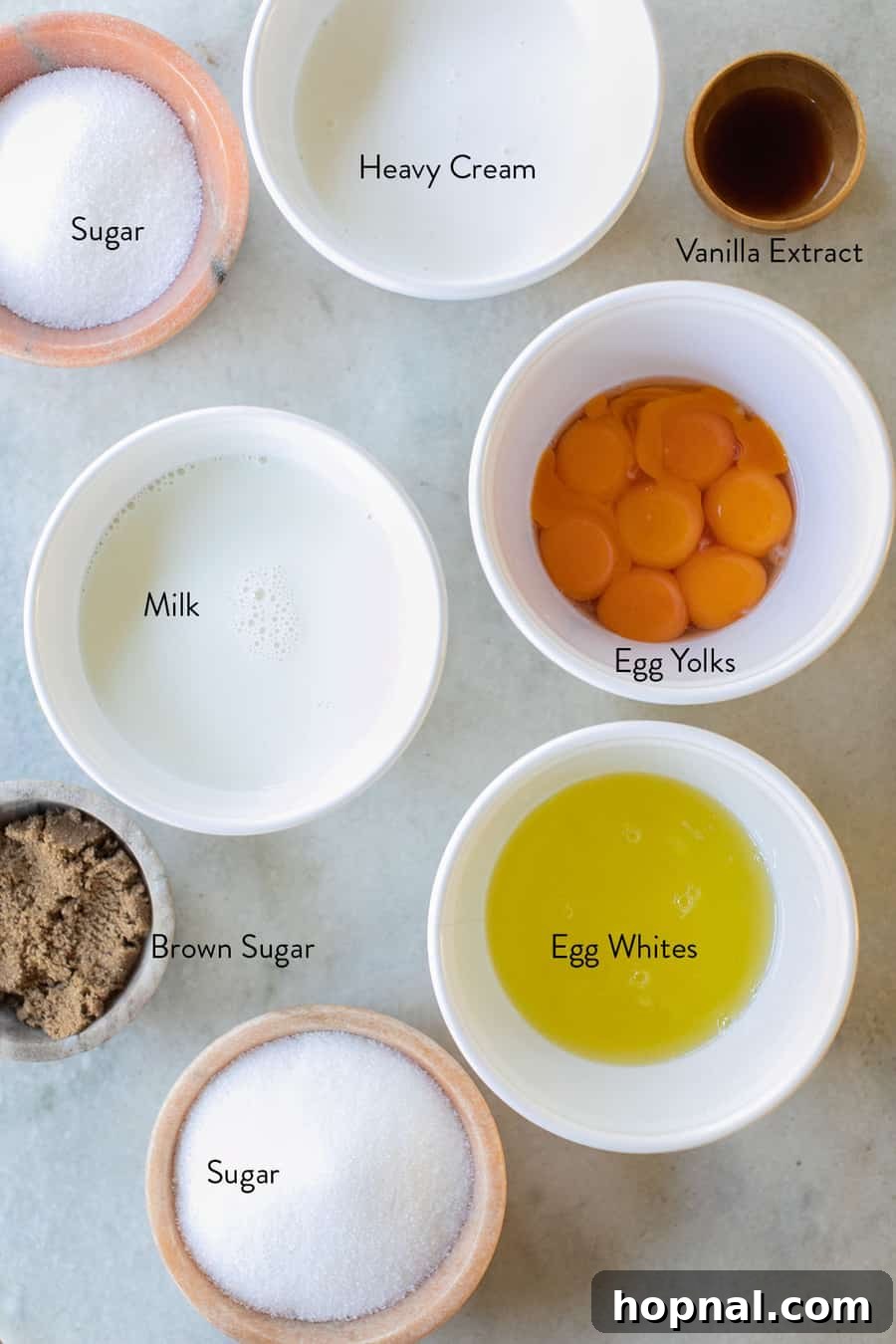 A flat lay of essential ingredients for spiked eggnog, including cinnamon sticks, freshly ground nutmeg, and a prepared glass of the drink.