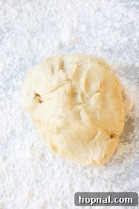 Festive Eggnog Cinnamon Buns 15 cinnamon roll dough rising in a greased bowl