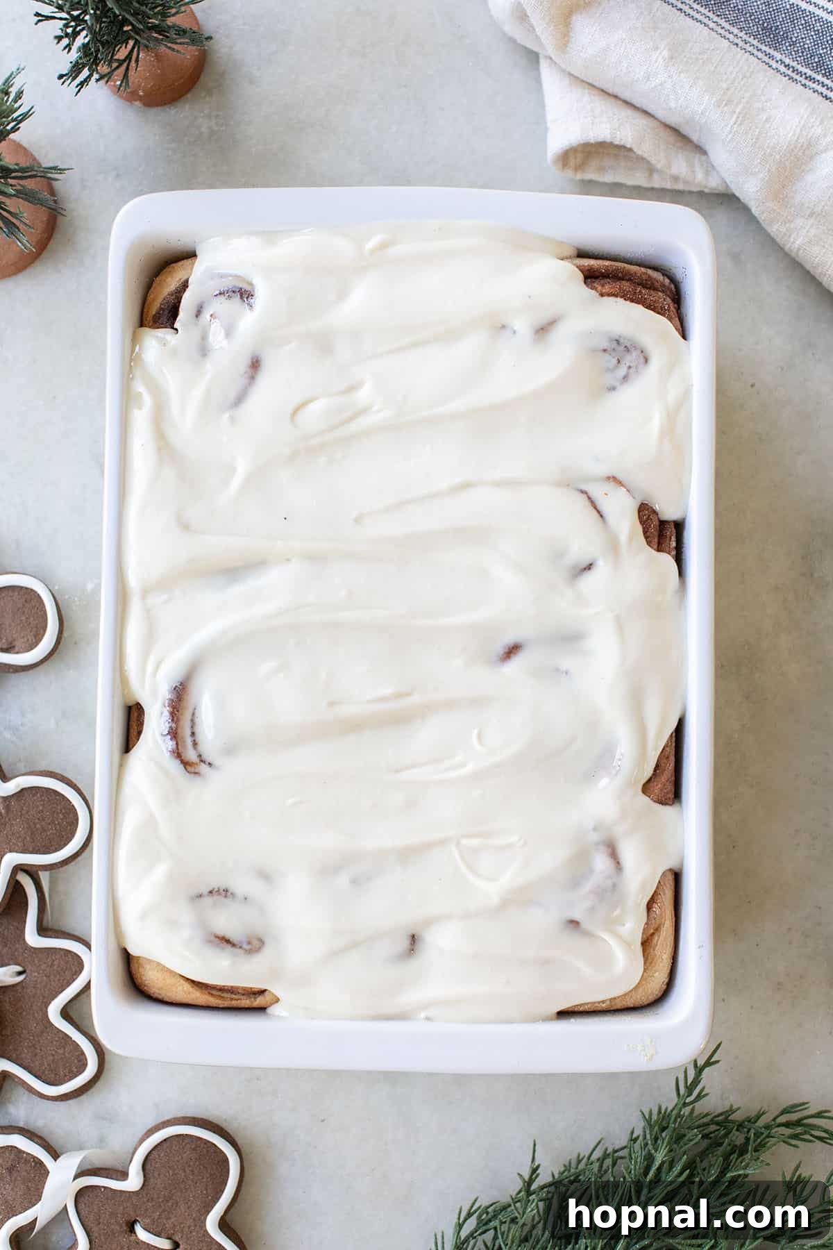 Festive Eggnog Cinnamon Buns 3 Close-up of homemade eggnog cinnamon rolls topped with thick cream cheese icing.