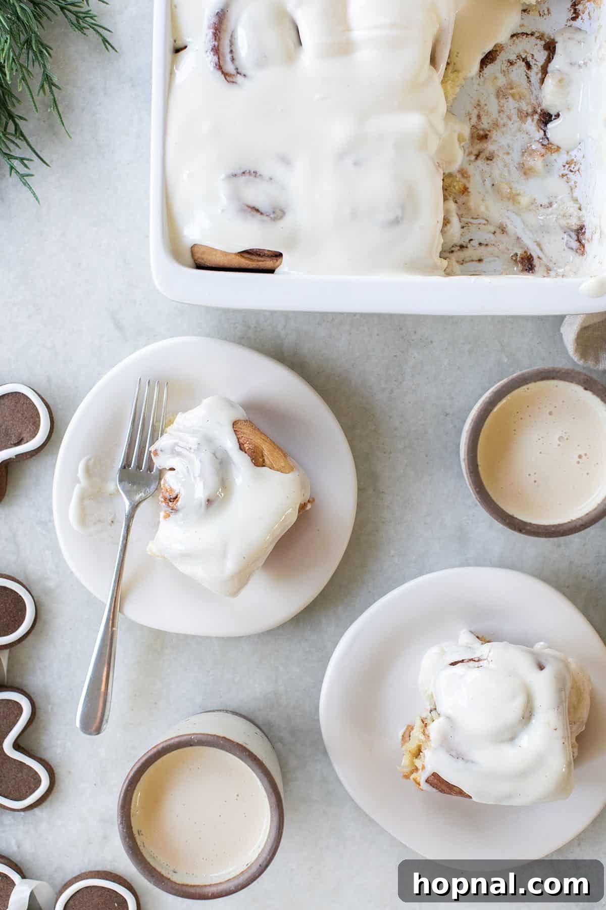 Festive Eggnog Cinnamon Buns 7 Gooey, freshly baked cinnamon rolls generously topped with homemade eggnog glaze in a square baking dish.