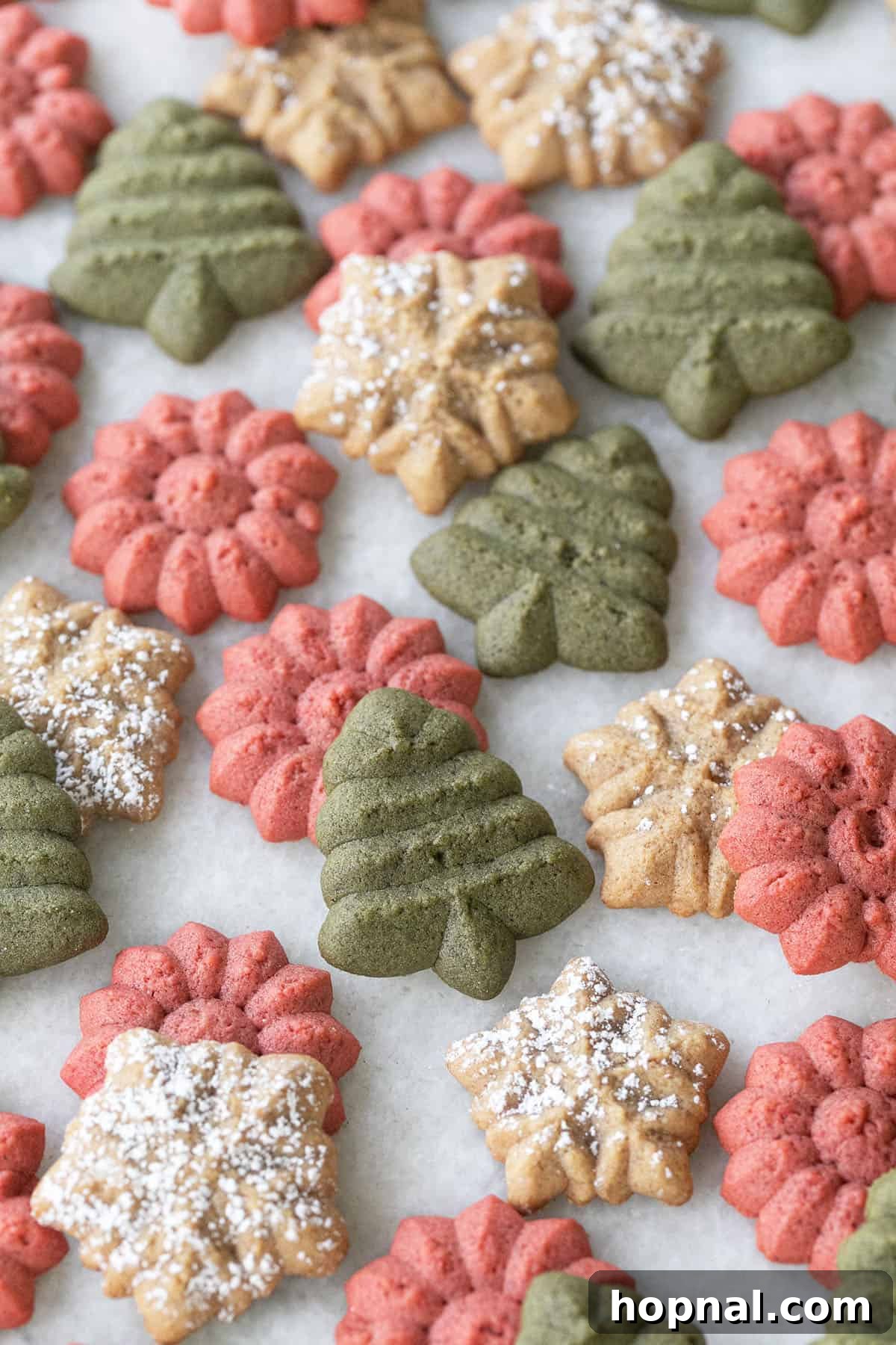 Melt-in-Your-Mouth Spritz Cookies 5 Little spritz cookies with gingerbread spice shaped in Christmas trees and snowflakes, ready to be enjoyed.