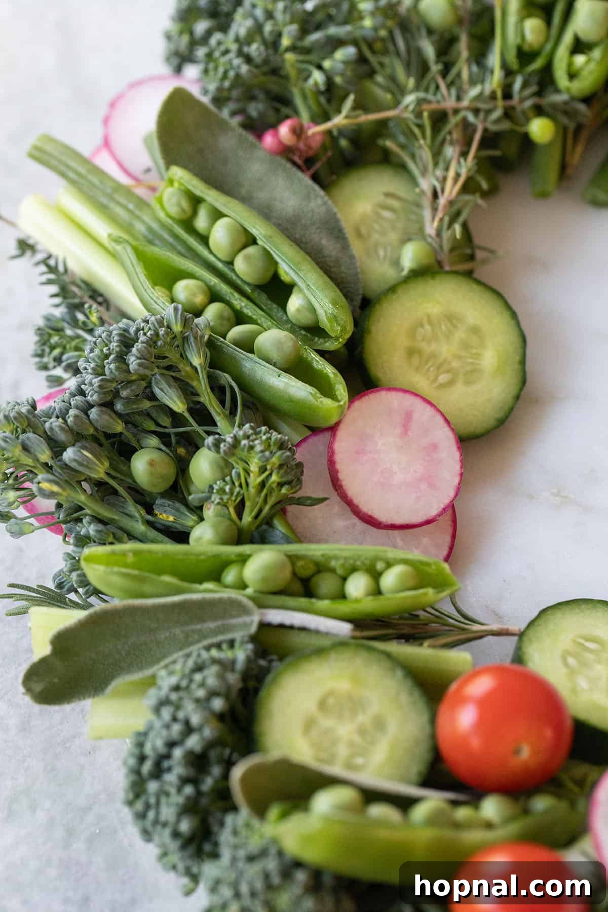Fresh green vegetables being sliced to form a holiday wreath appetizer.