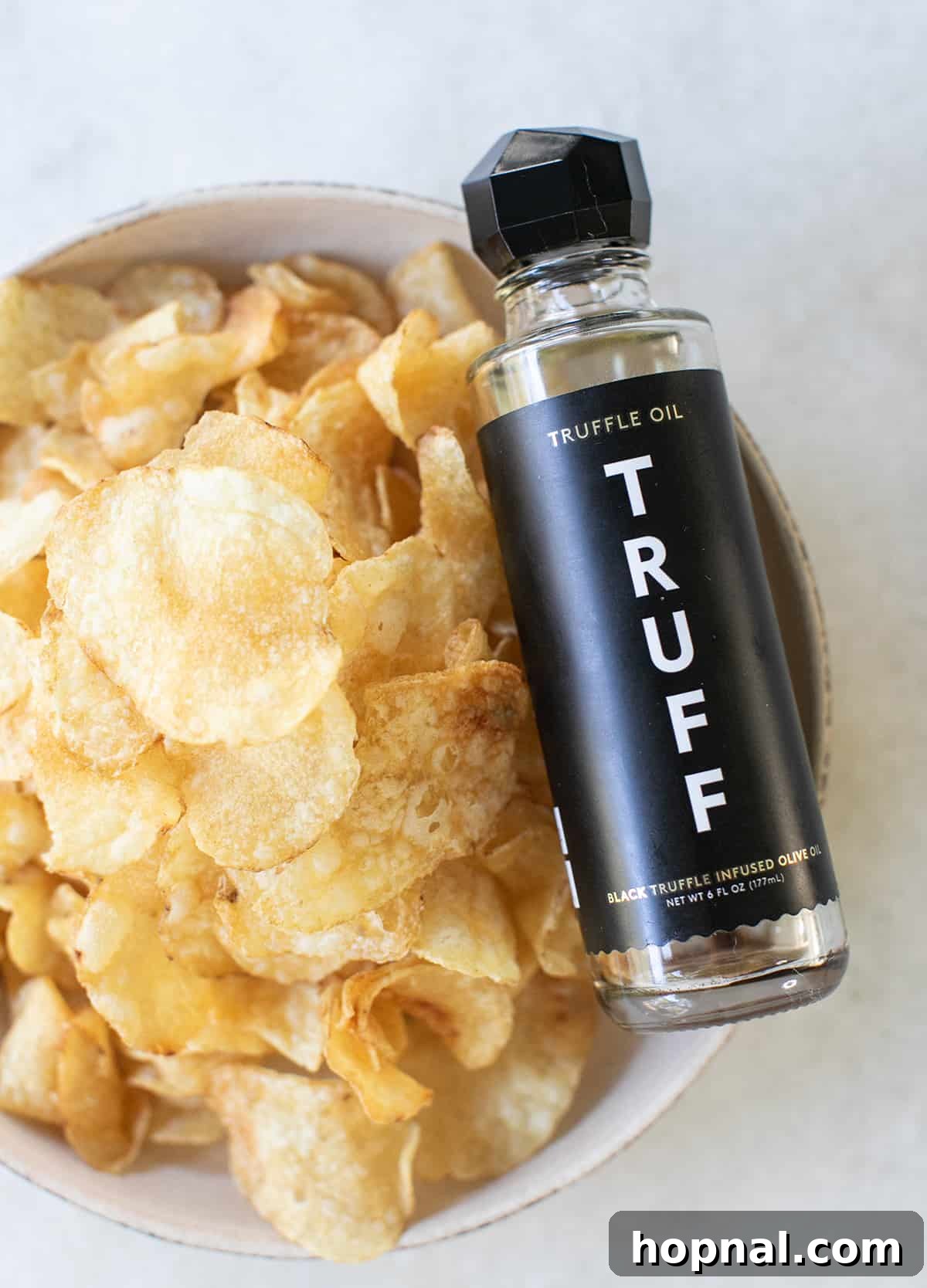 Exquisite Truffle Potato Chips with Prosciutto: A close-up of crispy chips layered with thinly sliced prosciutto and glistening with black truffle oil, an indulgent no-cook appetizer.