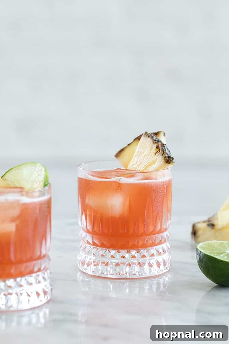 Tropical Jungle Bird cocktail in a tiki glass with pineapple and cherry garnish