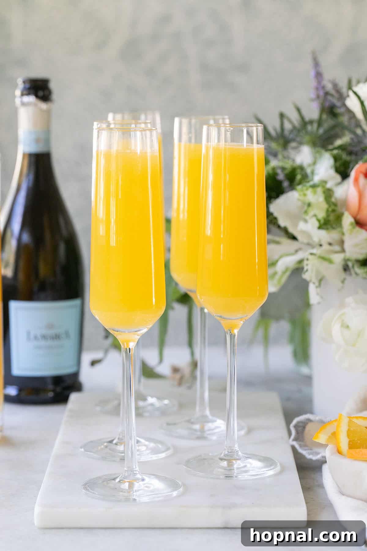 Sparkling Prosecco Mimosas garnished with orange slices on a table