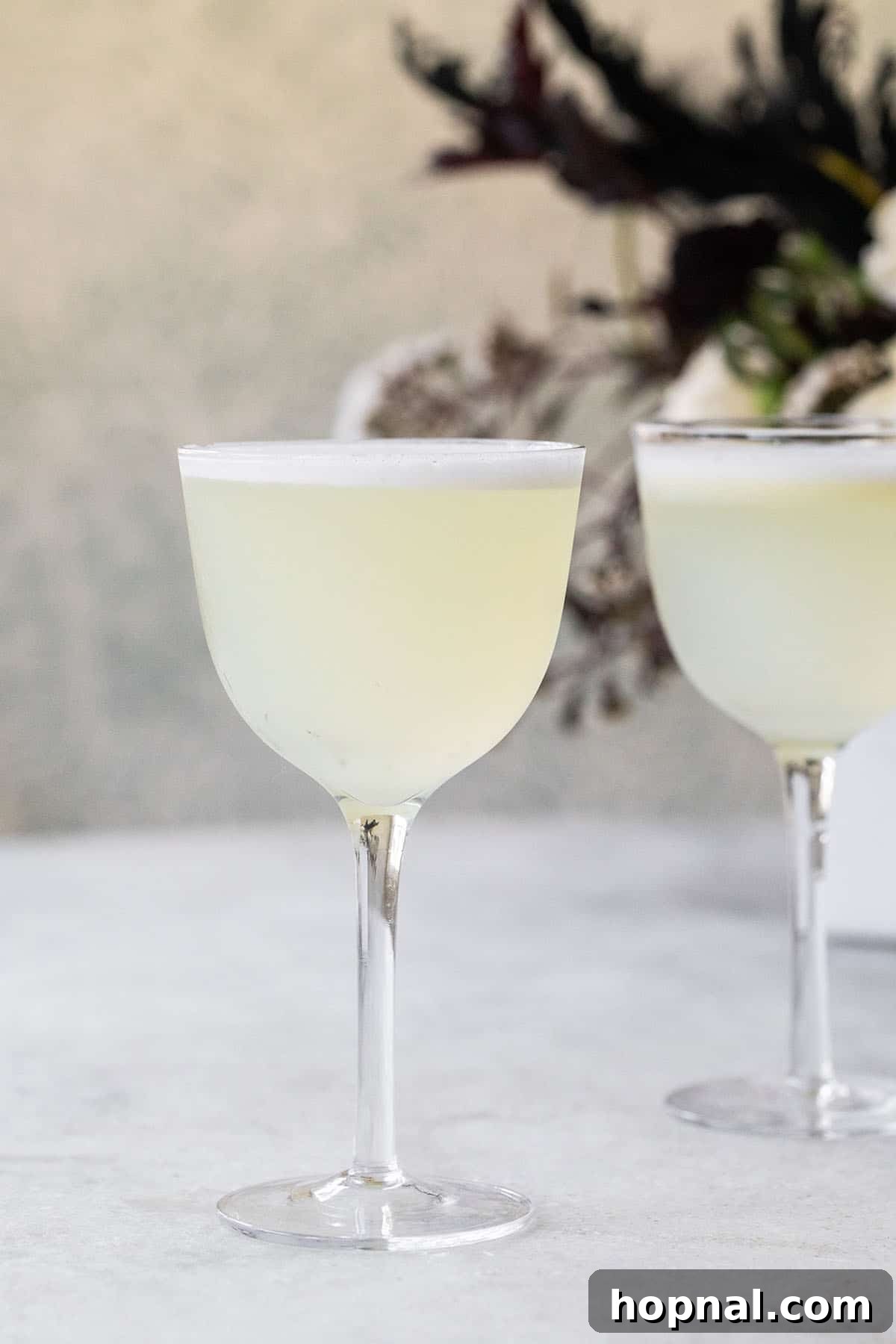 A sophisticated White Lady cocktail, featuring a frothy top, served in a coupe glass.
