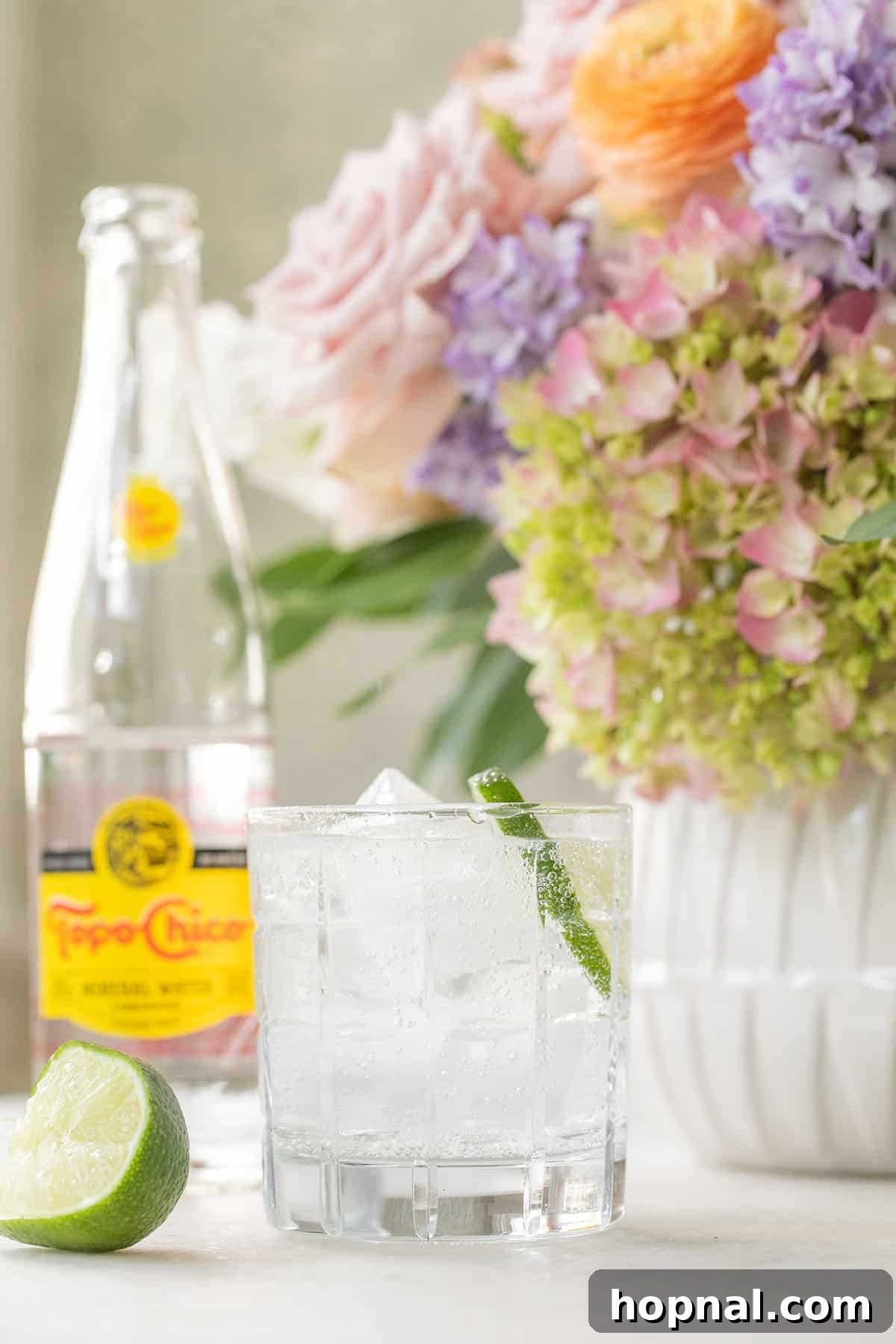 Everything You Need to Know About Topo Chico 4 A glass of Topo Chico with ice and a lime wedge, ready to drink