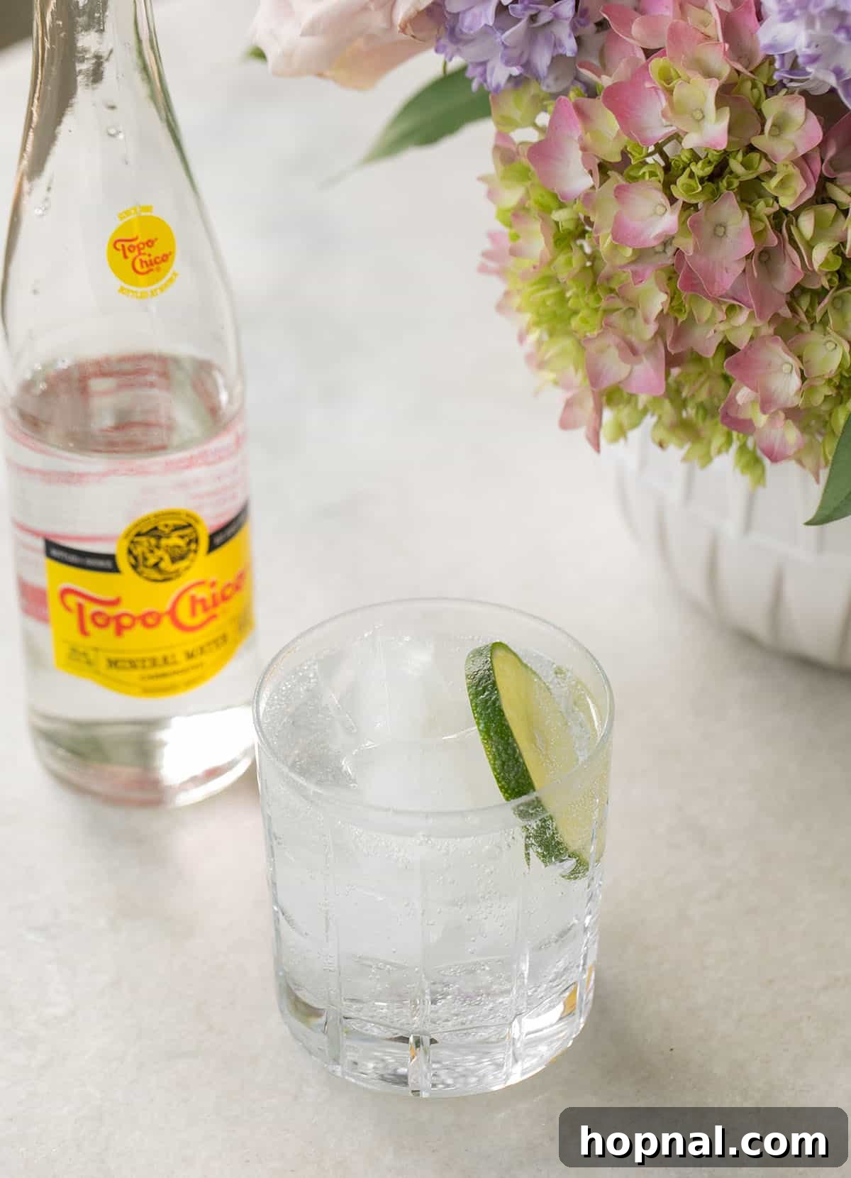 Everything You Need to Know About Topo Chico 5 Easy Topo Chico mocktail with lime and a sprig of mint