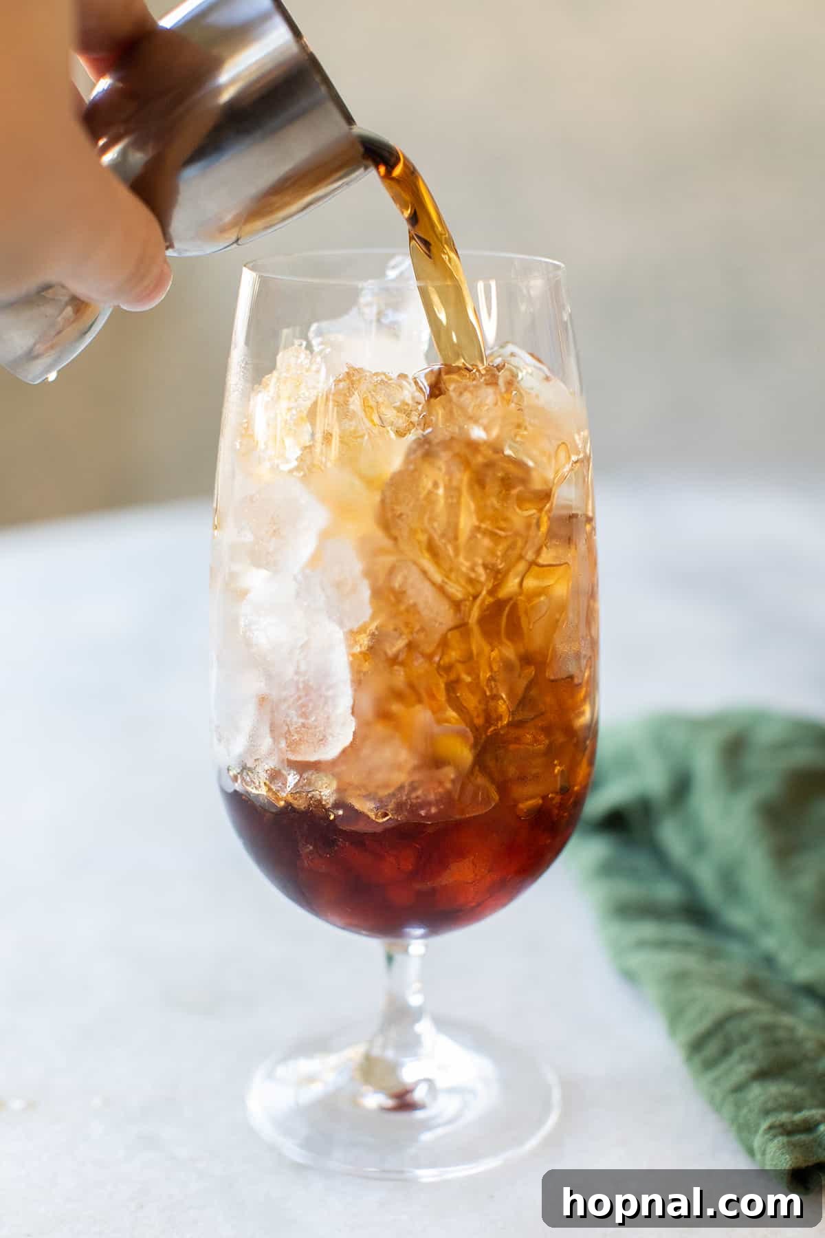 Pouring Jagermeister into a glass filled with ice