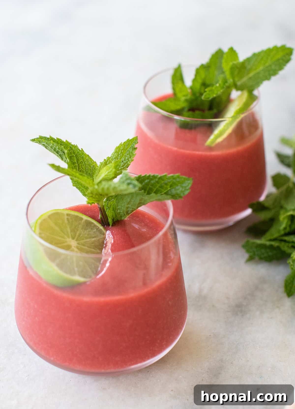 Blush & Sip 11 Frozen strawberry daiquiri in glasses with fresh mint.