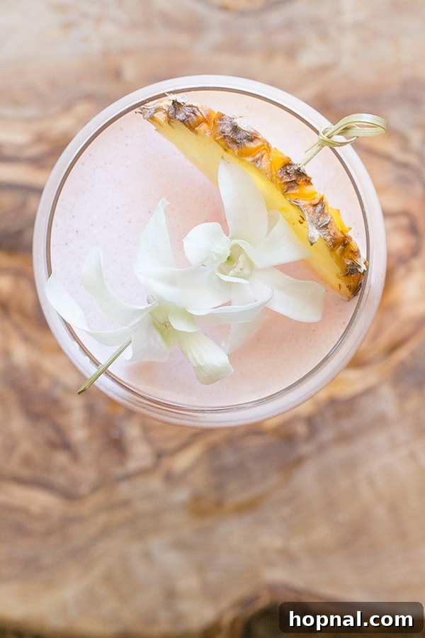 Blush & Sip 15 Tiki drink recipe with pineapple and flowers.