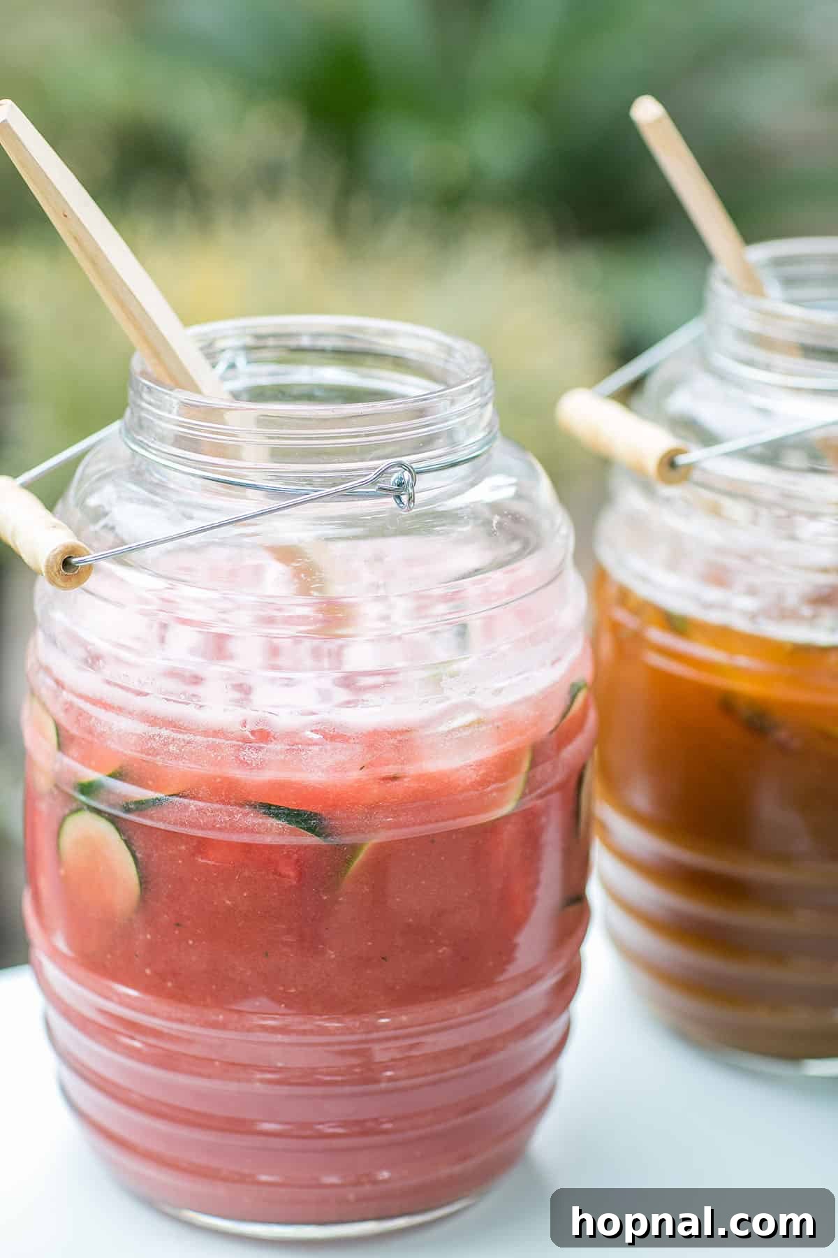 A glass of vibrant watermelon agua fresca with lime wedges and mint, ready to be enjoyed.