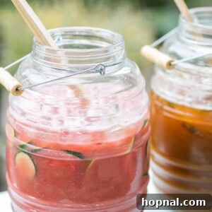 A glass of vibrant watermelon agua fresca, garnished with a lime wedge and a sprig of mint.