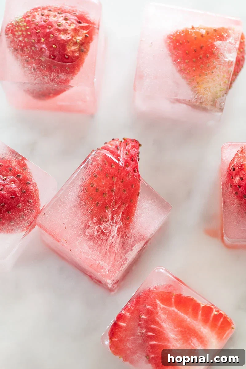 Vibrant strawberry ice cubes in a glass, ready for a refreshing drink.