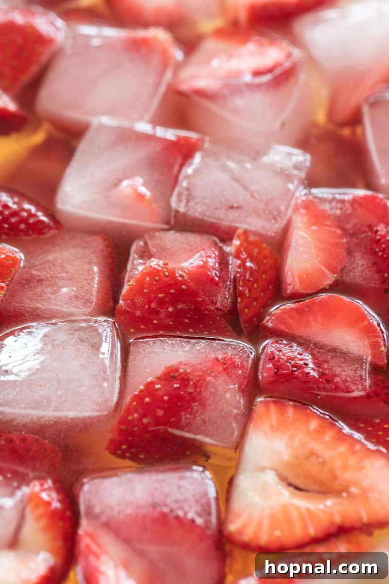 Strawberry ice cubes floating in a vibrant punch bowl, adding color and flavor.