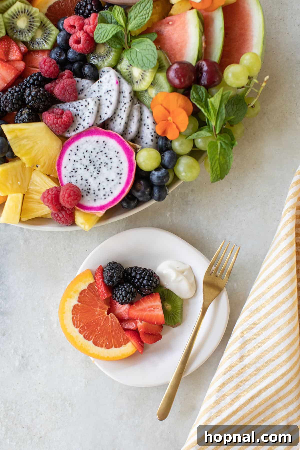 A small plate featuring fresh fruit alongside a dipping bowl filled with a creamy fruit dip.