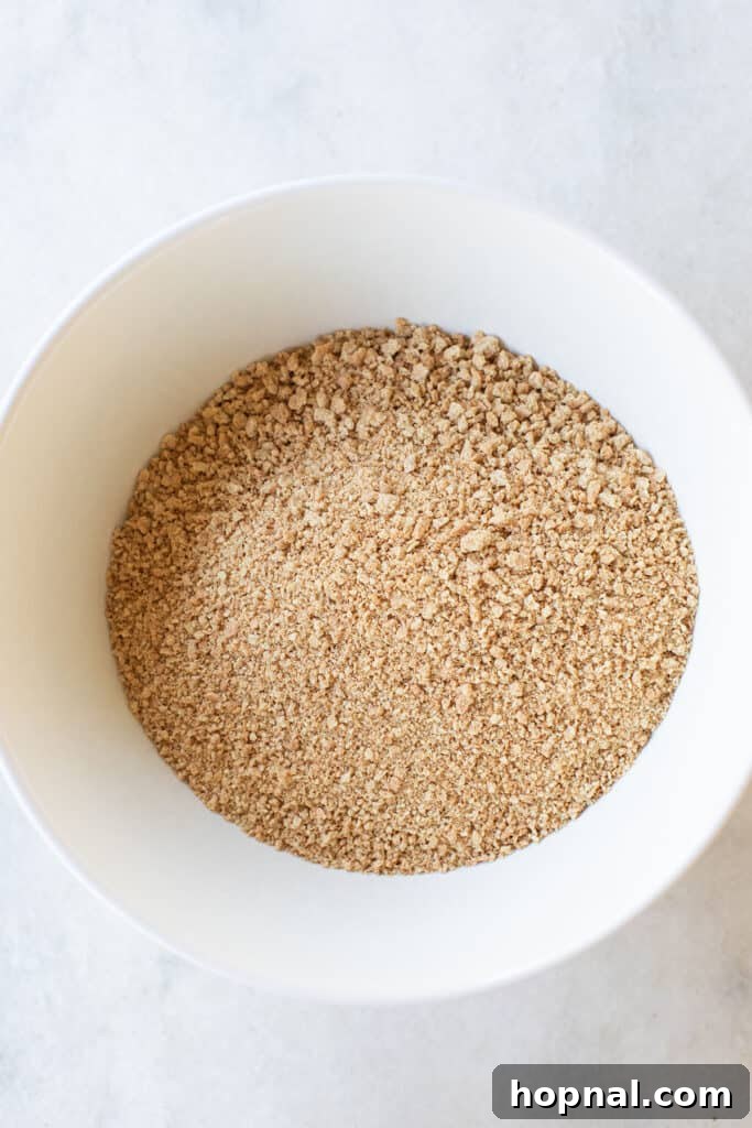 Finely crushed graham cracker crumbs neatly collected in a mixing bowl, ready for the next step of the recipe.