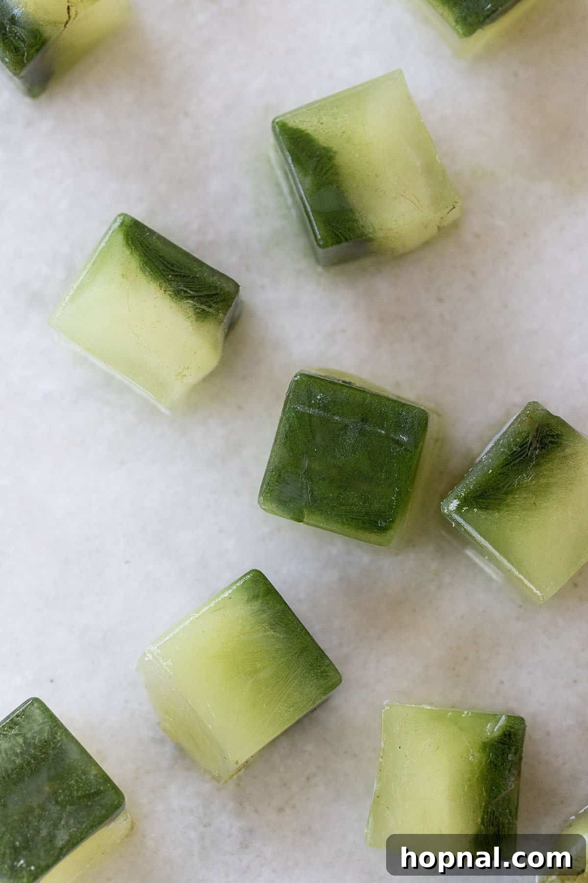 Vibrant green matcha ice cubes in an ice tray, ready to be used in an iced latte.