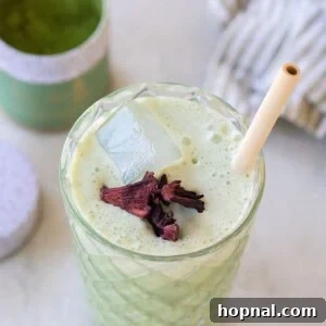 iced matcha latte in a tall glass with a bamboo straw