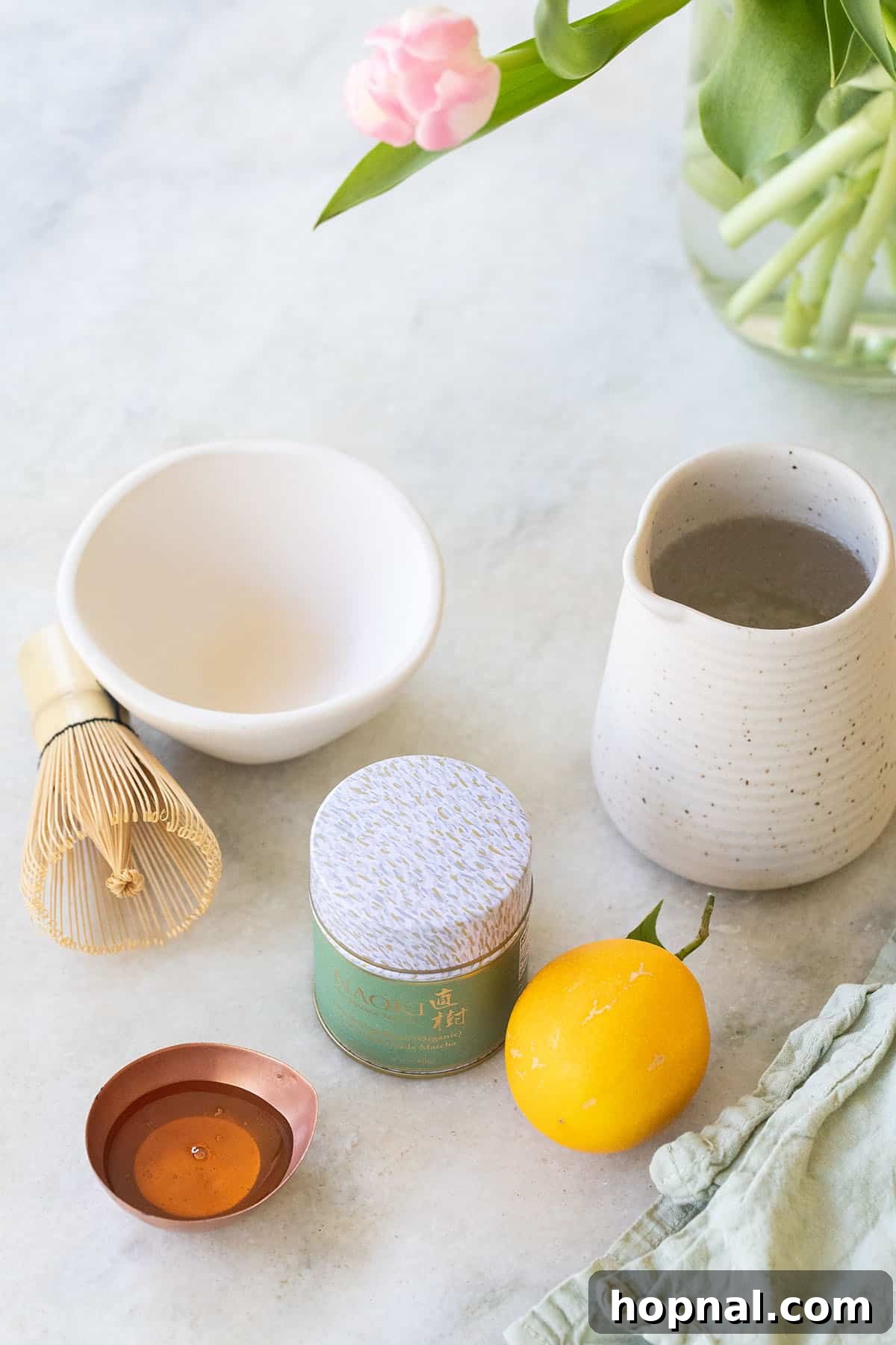 Matcha Spritz: Your Cool Green Escape 3 Ingredients laid out for making a matcha spritz including matcha powder, honey, and lemon.