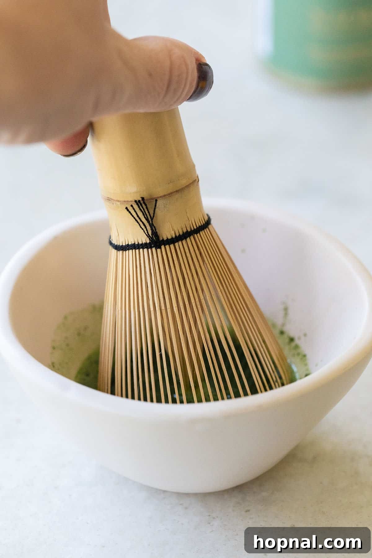 Matcha Spritz: Your Cool Green Escape 4 Whisking matcha powder in a small bowl to create a smooth paste.