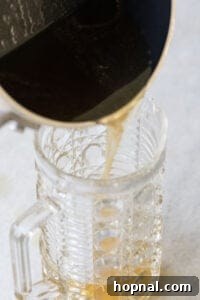 pouring honey syrup into a glass