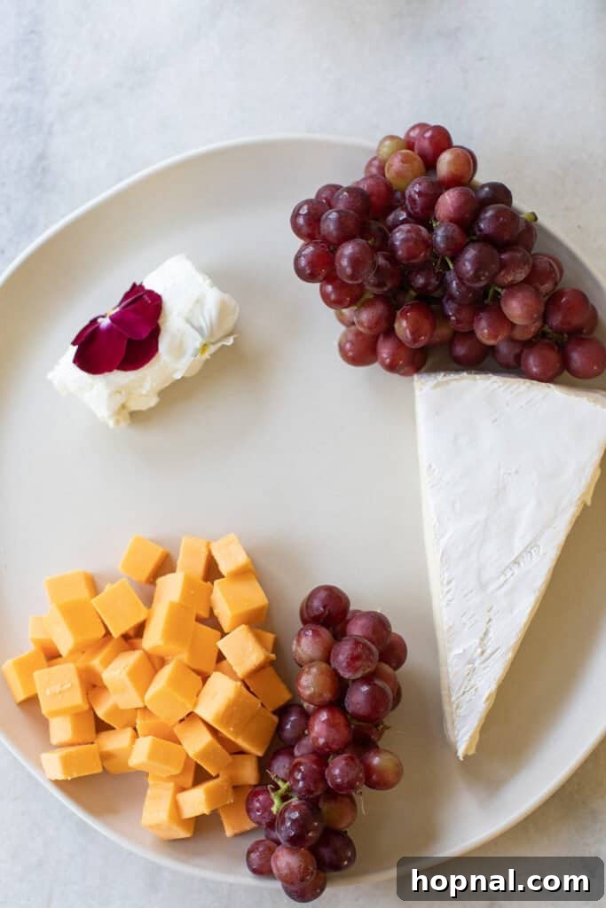 Elegant Cheese and Fruit Board 5 Fresh green grapes and artisanal cheese segments arranged on a round serving platter.