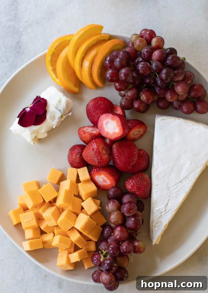 Elegant Cheese and Fruit Board 6 A vibrant round platter featuring a mix of grapes, fresh strawberries, and various cheeses, creating a colorful display.