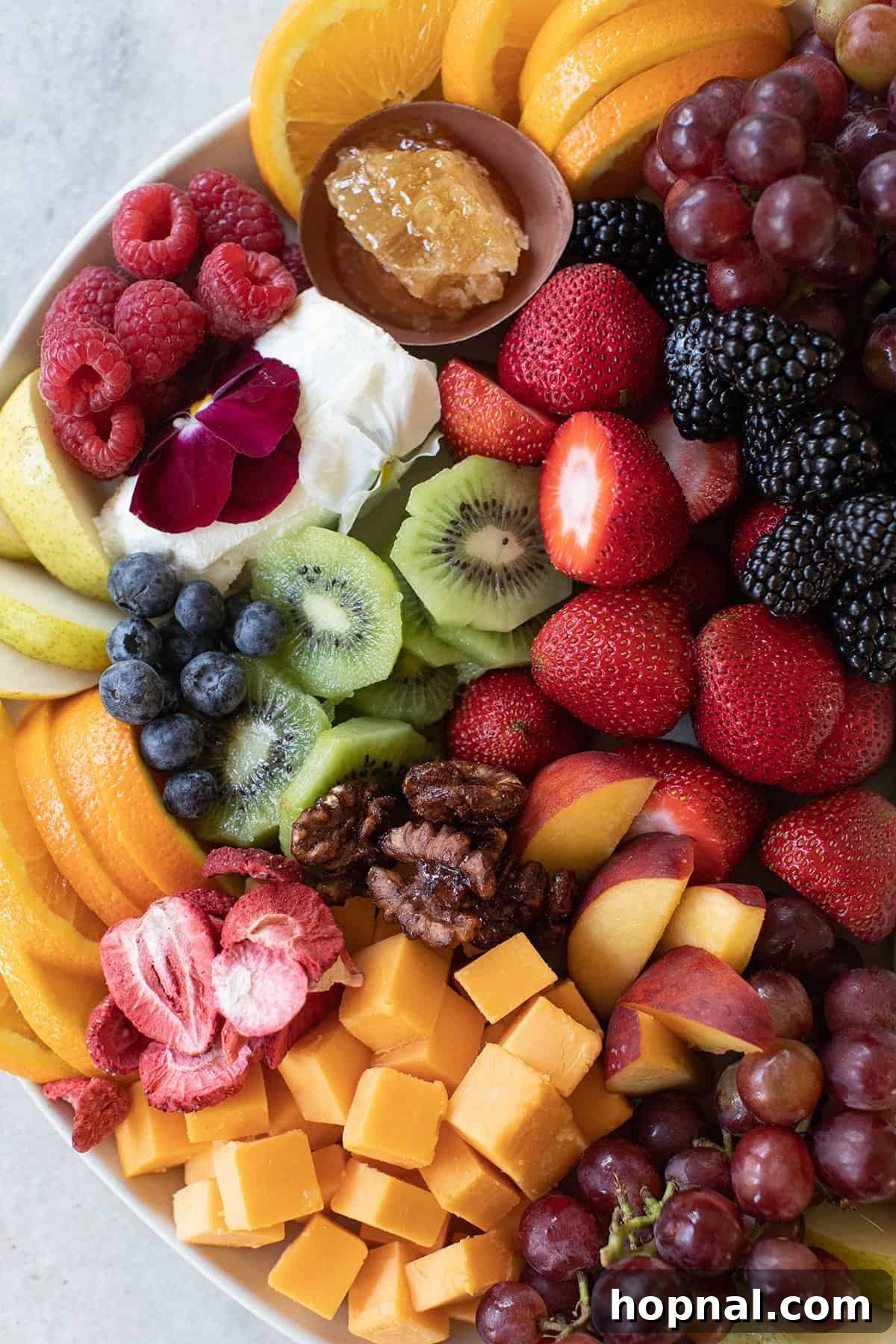 Elegant Cheese and Fruit Board 8 A vibrant display of freshly sliced kiwi, strawberries, oranges, peaches, blackberries, and pears, creating an inviting spread of fruit.