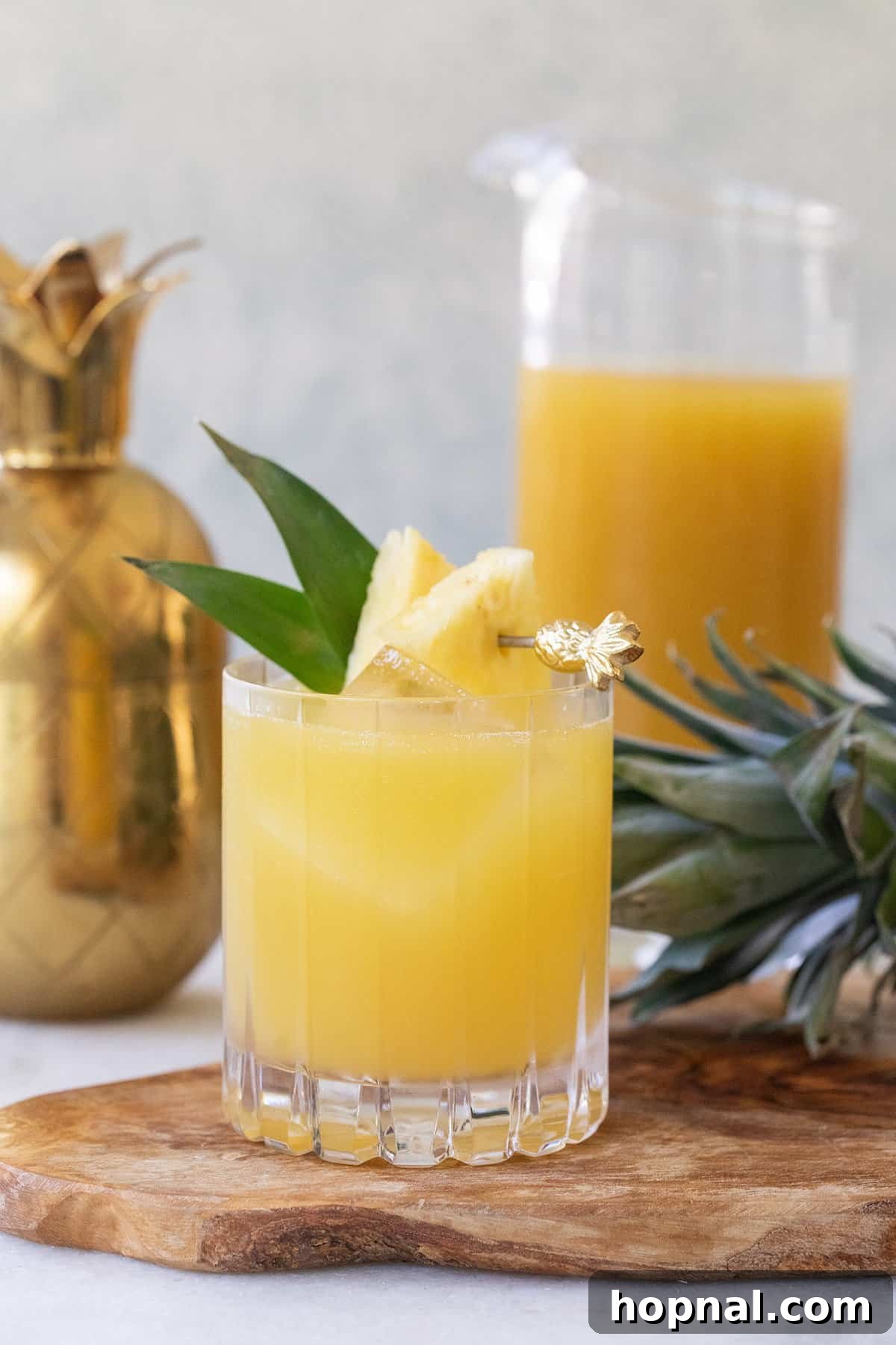 Tropical Pineapple Vodka Elixir 2 A refreshing Pineapple Vodka Cocktail served in a tall glass with ice and a pineapple wedge garnish.