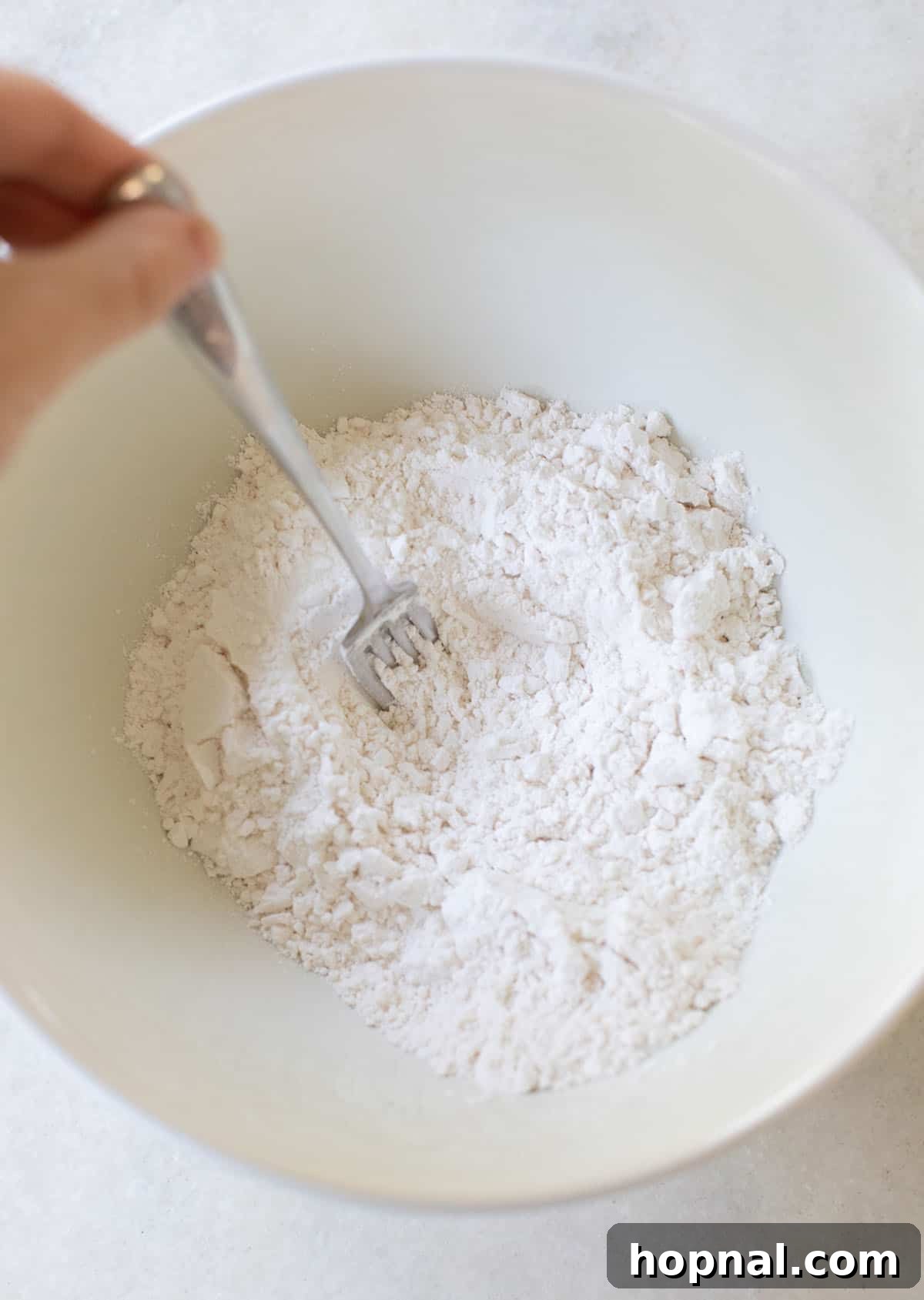 Unlock Fluffy Cakes: Cake Flour Recipes 8 A person sifting cake flour into a bowl, demonstrating a key step in preparing homemade cake flour for consistent results.