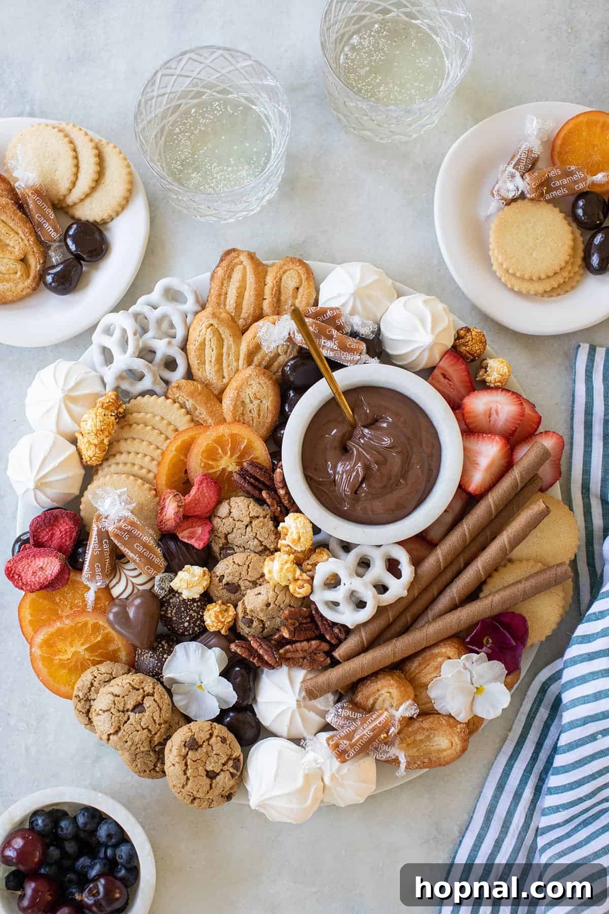 Sweet Grazing Board 2 An elaborate dessert charcuterie board brimming with an assortment of cookies, candies, and fresh fruit, making it an ideal centerpiece for any celebration.