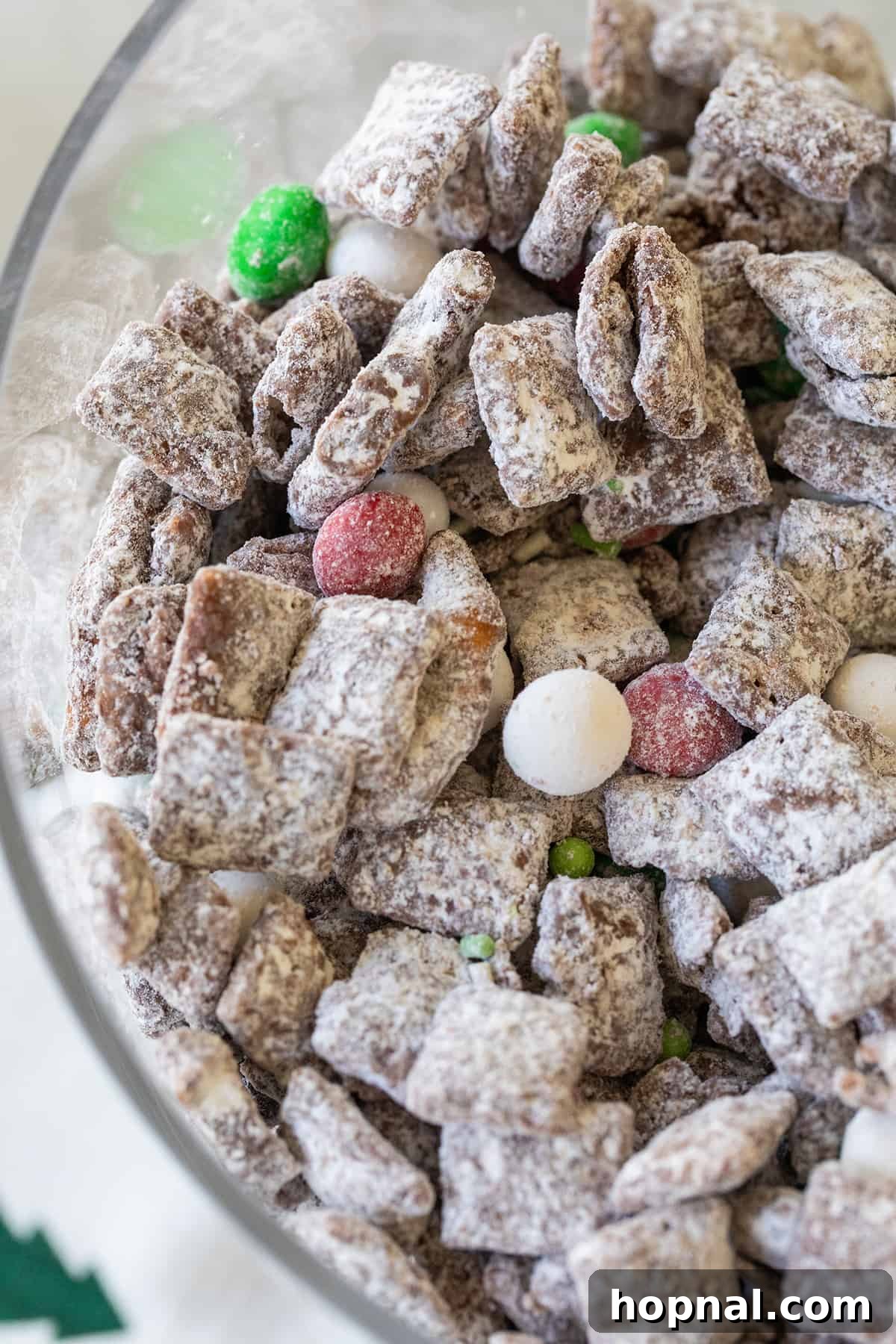 Magic Reindeer Dust 11 A close-up view of Christmas reindeer food, generously coated in powdered sugar, highlighting its appealing snowy texture and vibrant holiday sprinkles.