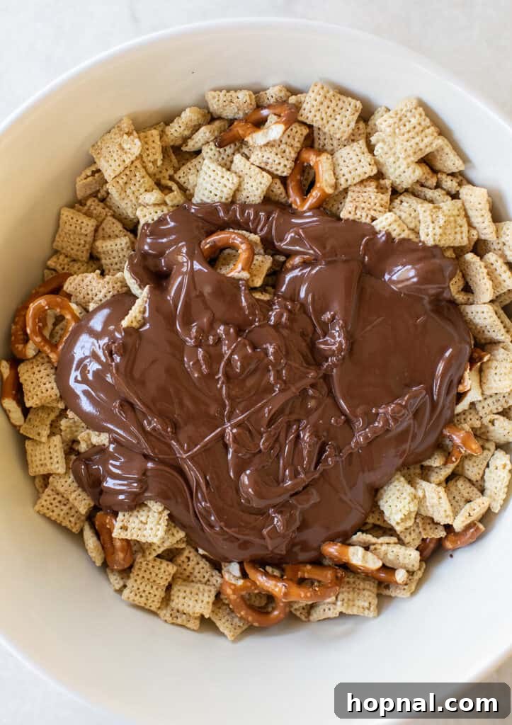 Magic Reindeer Dust 5 The smooth, melted chocolate and peanut butter mixture being poured over a generous quantity of crunchy Chex cereal in a large bowl.