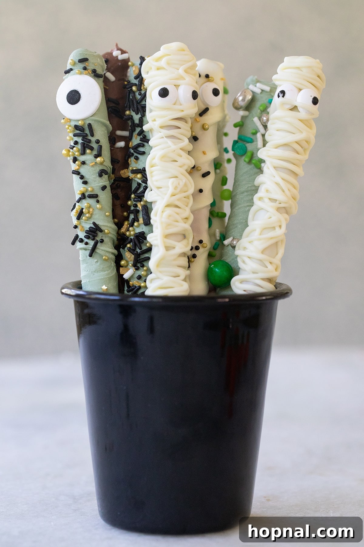 Halloween pretzel rods in a cup.
