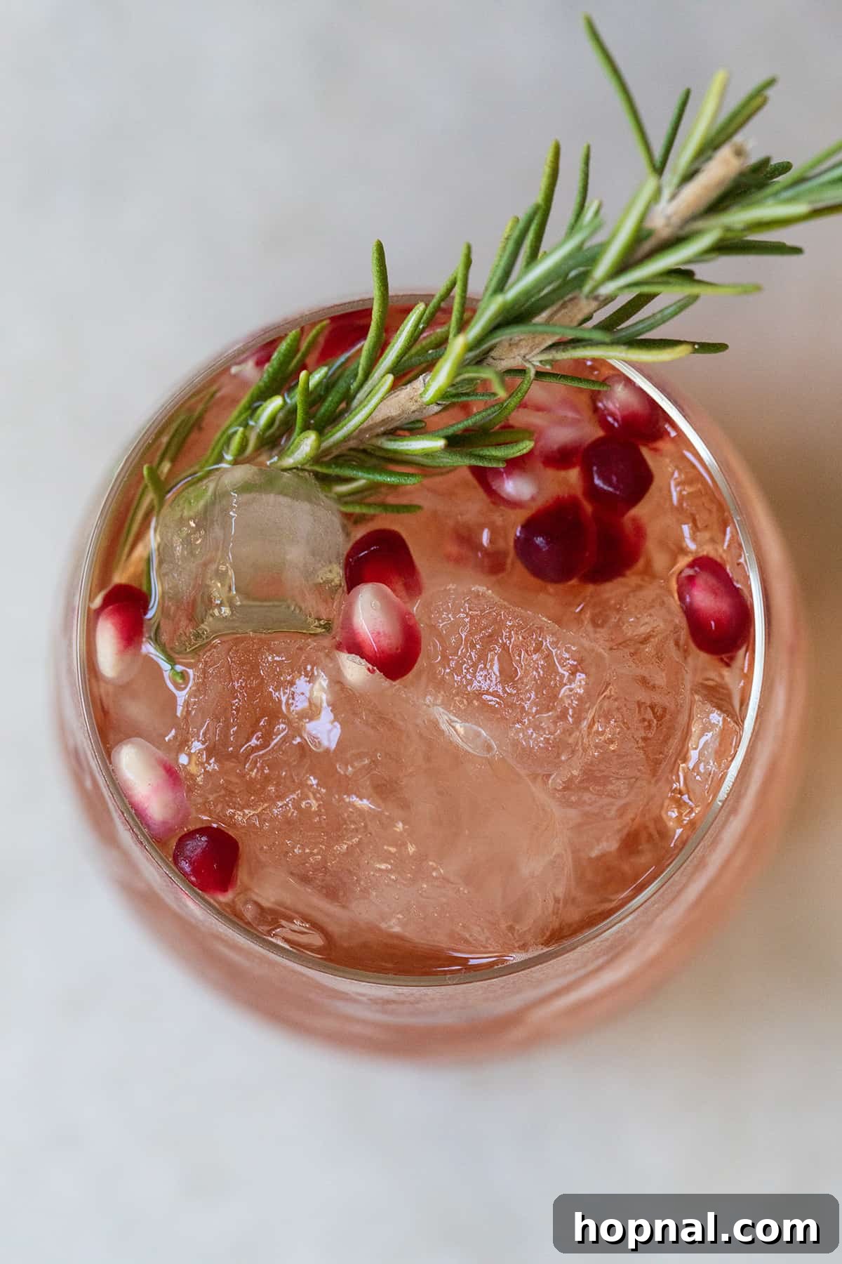 Festive Prosecco Fizz 4 Red holiday punch being prepared with rosemary and pomegranate.