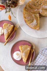apple upside down cake on a pink plate with whipped cream.