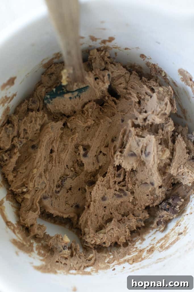 A scoop of espresso chocolate chip cookie dough on parchment paper, ready for baking.