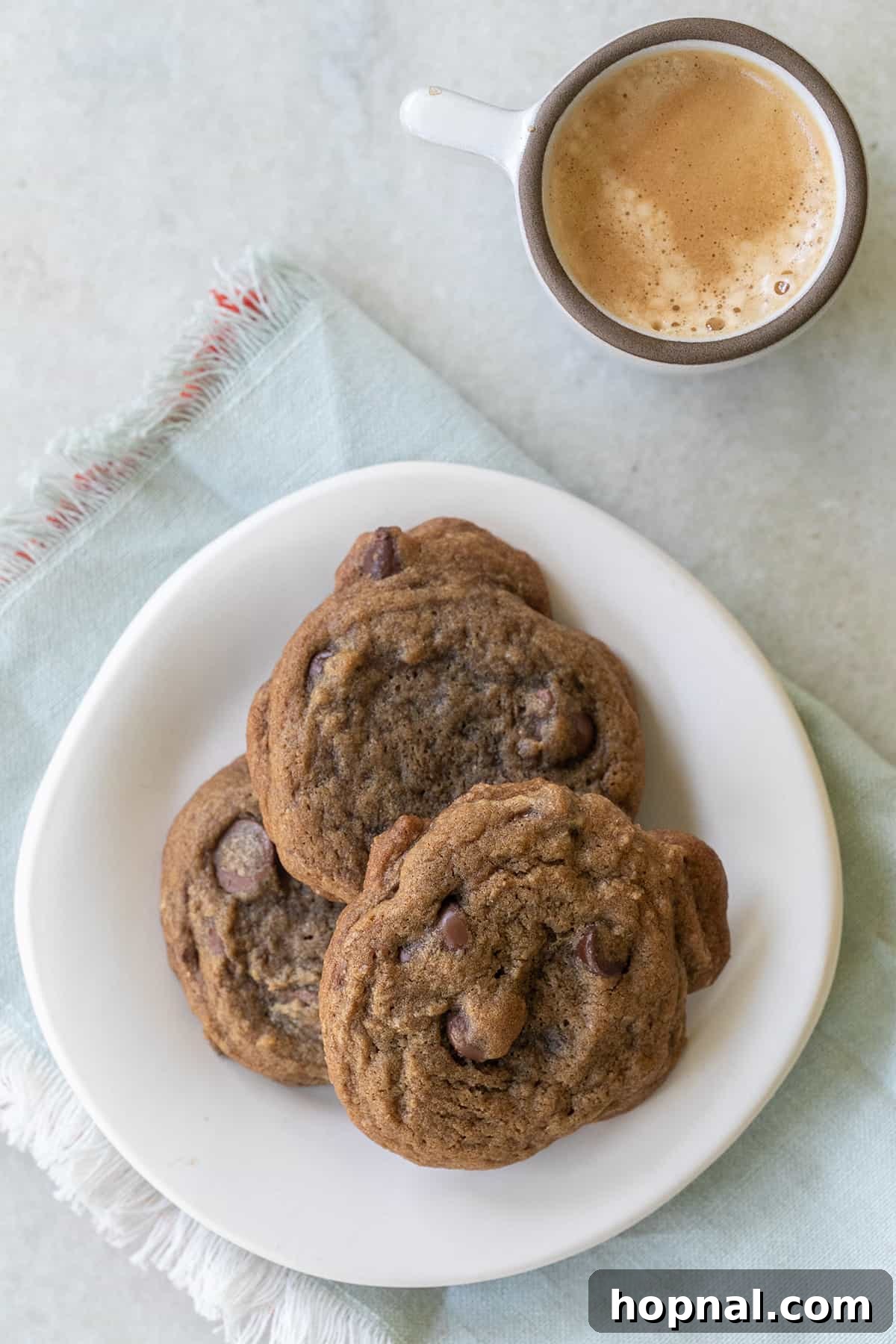 Three perfectly baked espresso cookies served on a white plate alongside a shot of freshly brewed espresso, ready for a delicious pairing.