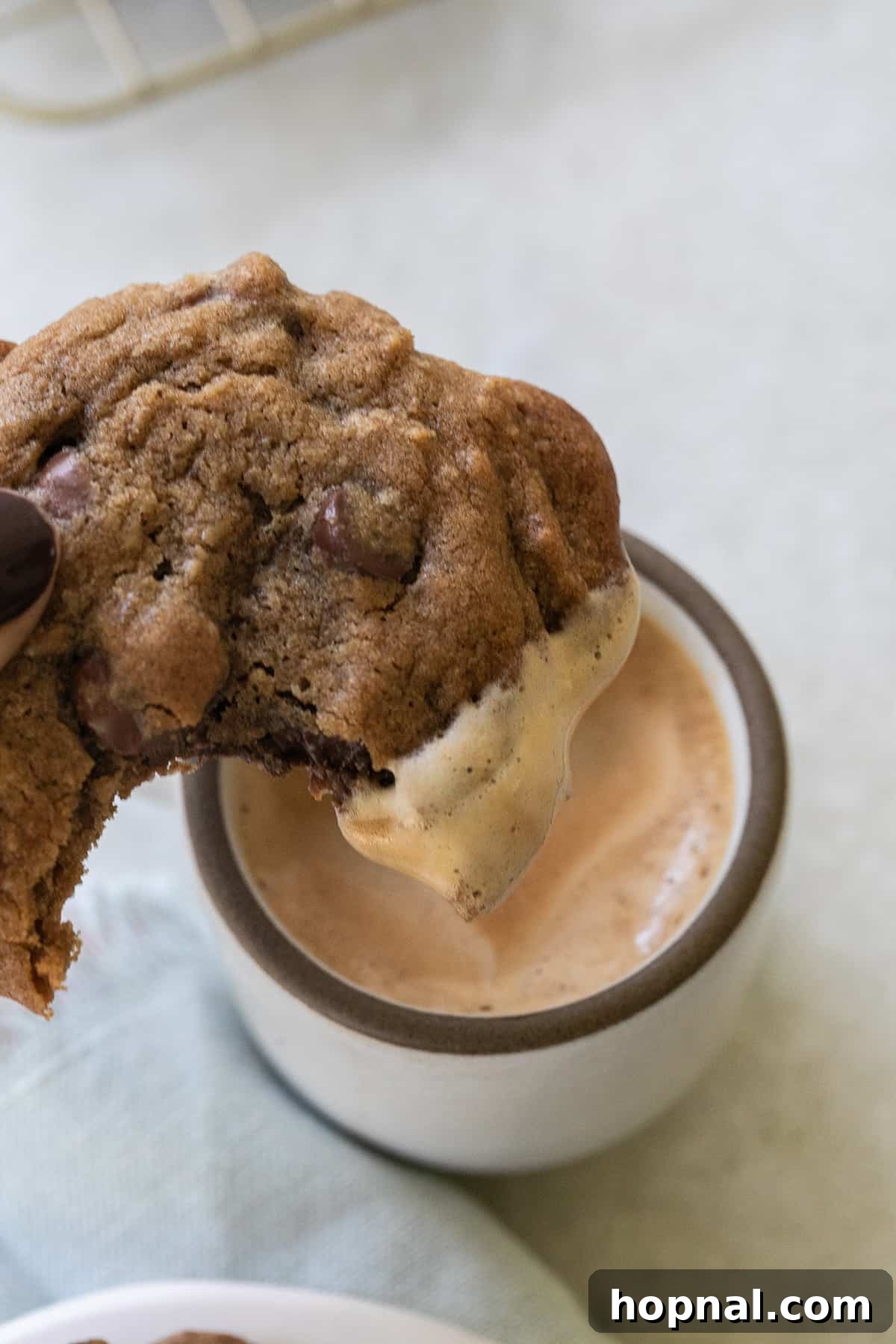 A delicious chocolate chip espresso cookie being dipped into a small cup of espresso, highlighting its perfect texture.