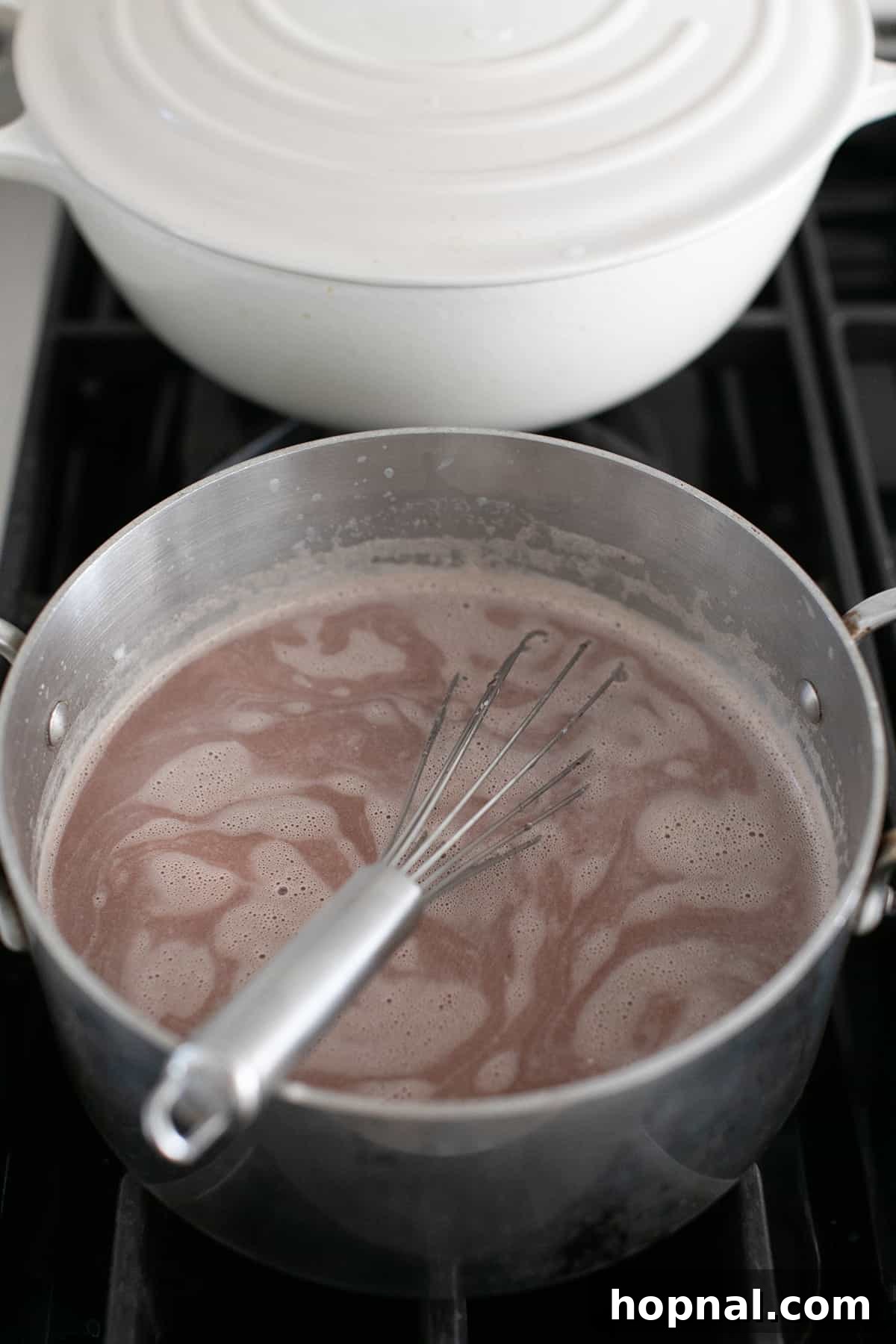 Mixing peppermint hot chocolate in a saucepan. 