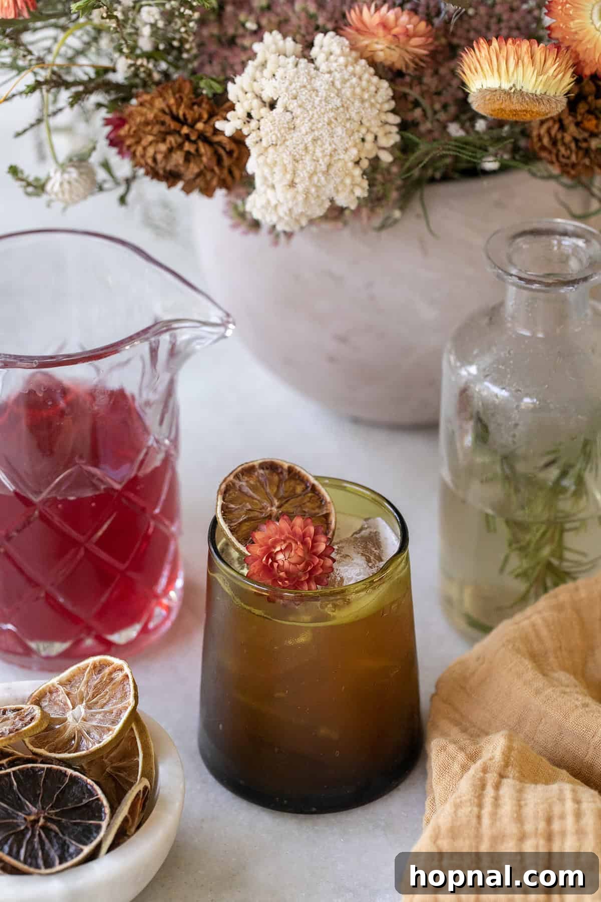 Thanksgiving mocktail in a green glass with cranberry juice and flowers. 