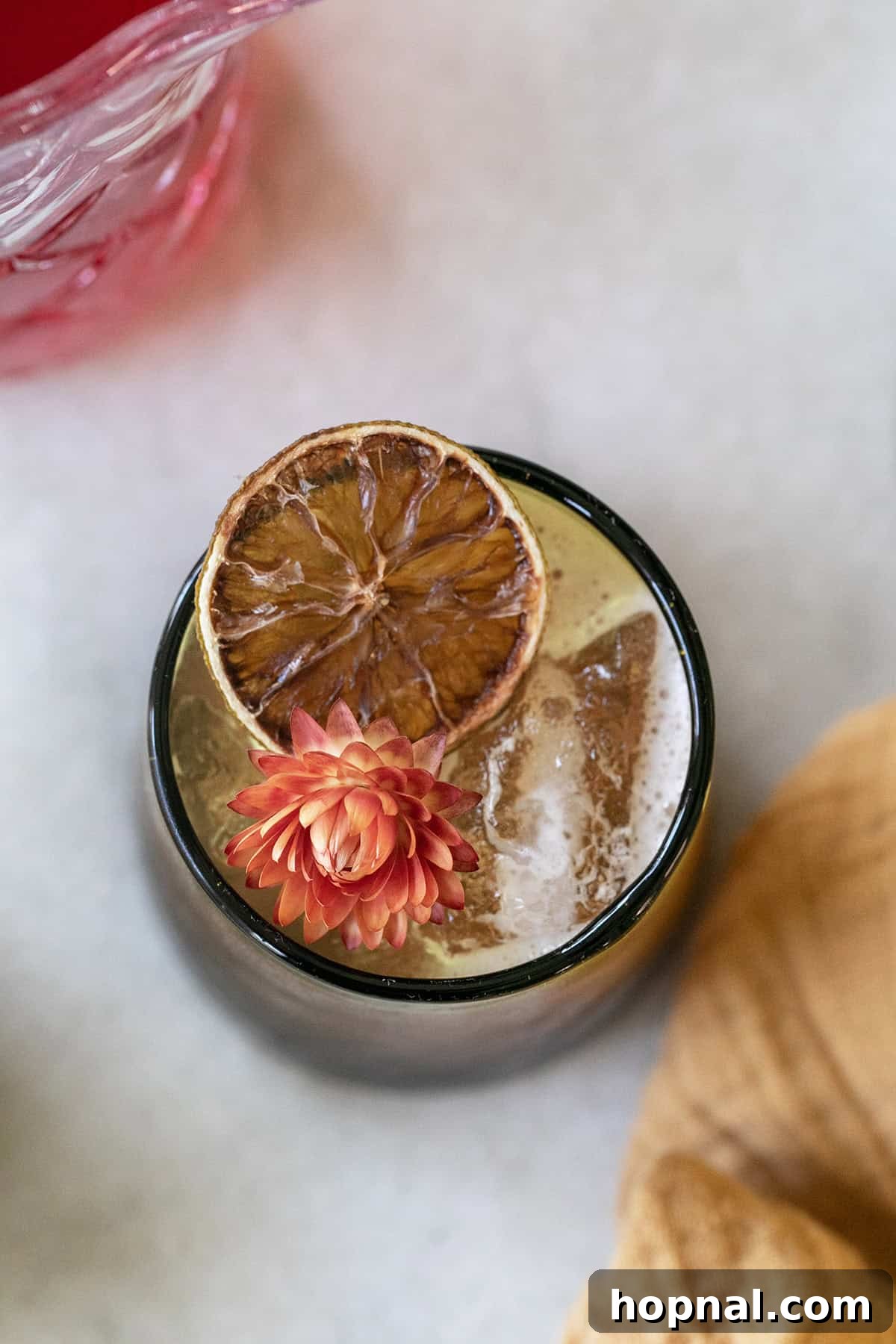 Thanksgiving cocktail in a glass with lime and a flower.