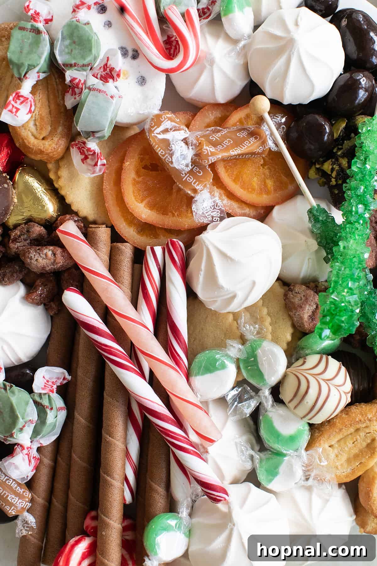 A festive Christmas dessert board filled with a variety of cookies, candies, and holiday treats, artfully arranged on a platter.