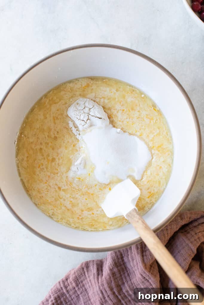Dry and wet ingredients being gently folded together in a mixing bowl.