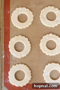 Wreath cookies neatly lined on a silicone baking mat ready for baking.