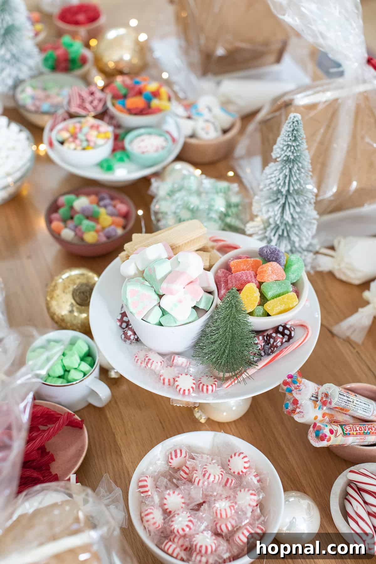 Gingerbread house making party with various candies, sprinkles, and icing on a festive table.